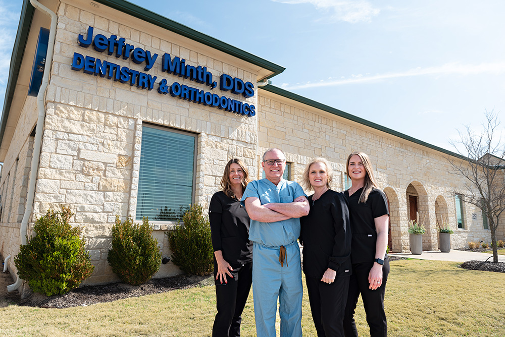 Dr. Jeffrey Minth and his skilled dental team standing proudly in front of our Rockwall dental office, dedicated to your oral health!